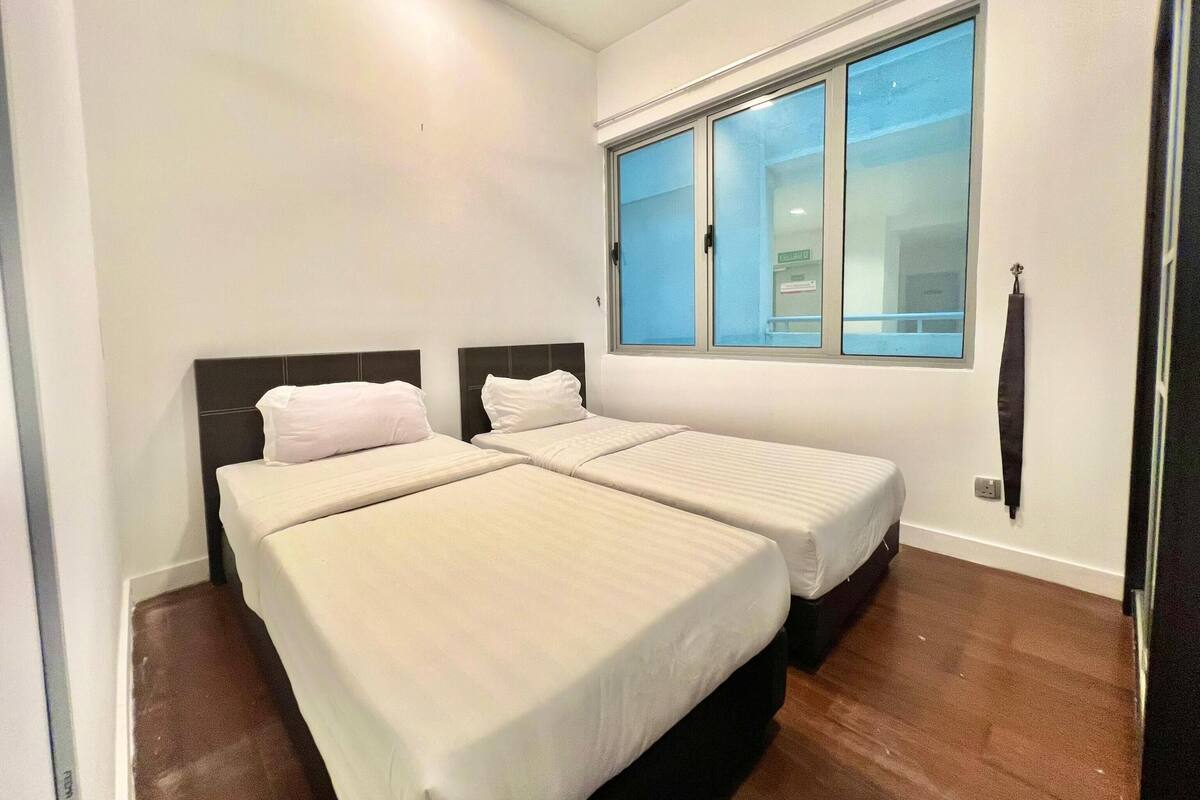 Una habitación con dos camas, una ventana y un ventilador de techo.