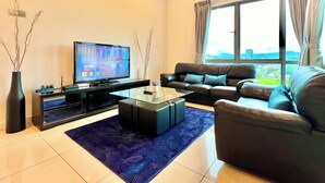 Una sala de estar moderna con un televisor de pantalla plana, un sofá de cuero y un ventanal con vistas a la ciudad.