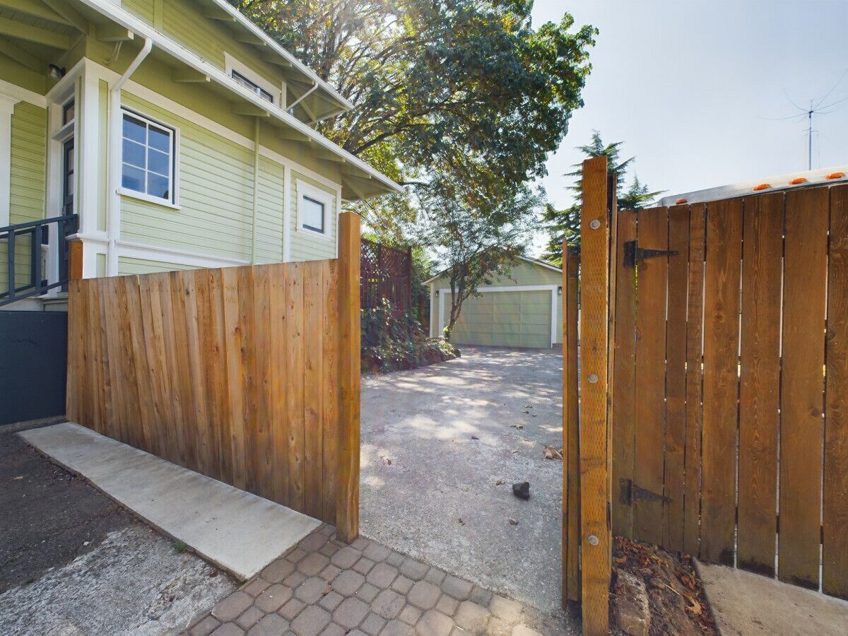 Il s’agit d’une propriété résidentielle dotée d’une clôture en bois, d’une allée pavée et d’un garage.