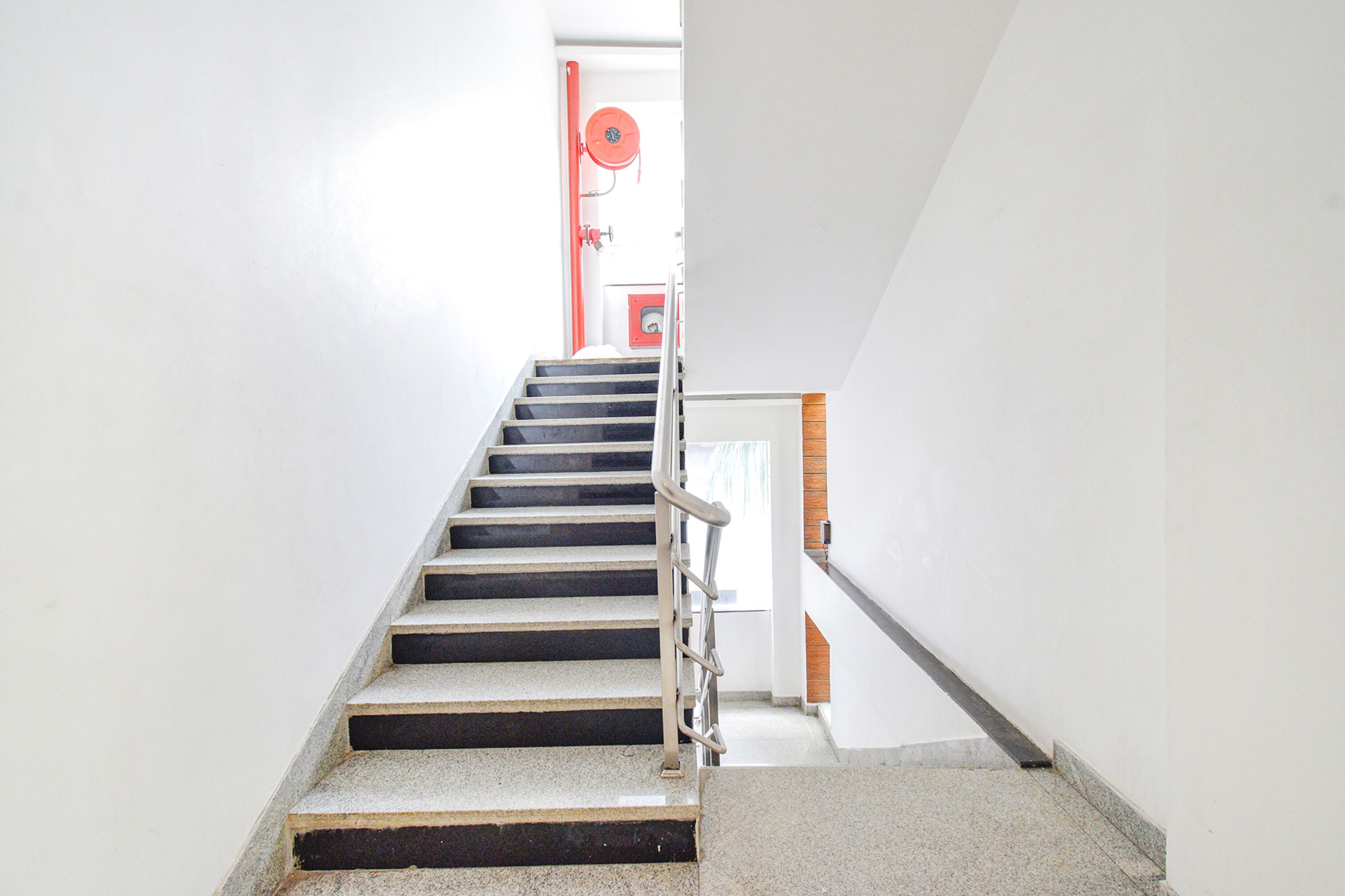 Una scala con ringhiera in metallo che porta a una porta.