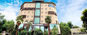 A multi-story hotel with a prominent 'Bellmont' sign at the entrance. - FabHotel Prime Bellmont (Noida)