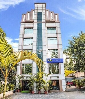 Un hotel moderno con una torre central de cristal, un letrero que dice 