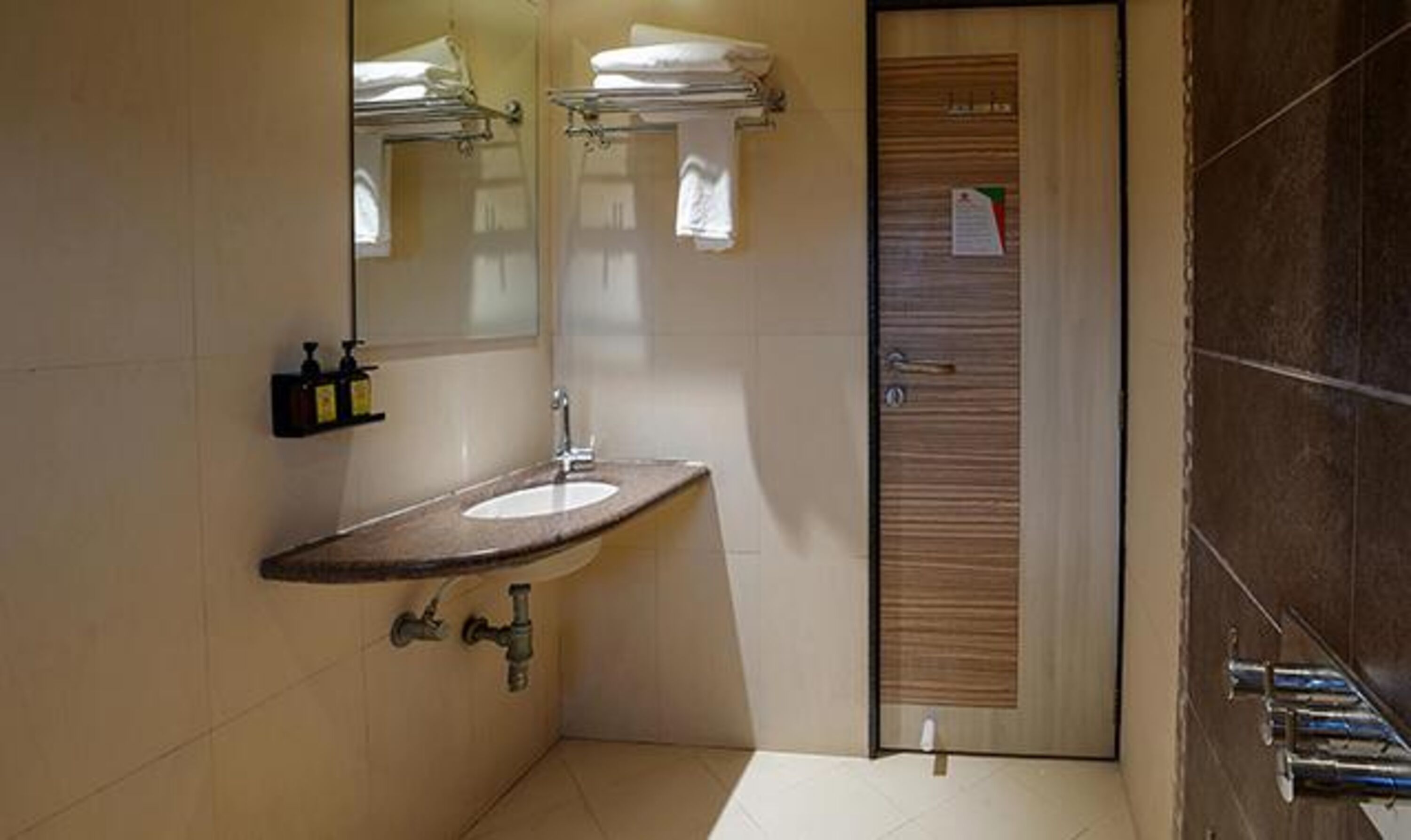 A bathroom with a sink, mirror, and a shower area.