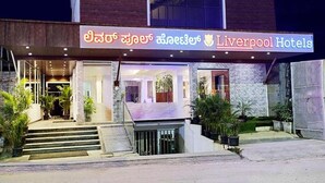A hotel entrance with a sign in multiple languages, including English, and a modern architectural design. - FabHotel Prime Liverpool Blue (Bengaluru)