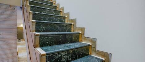 A staircase with marble steps and wooden handrails.