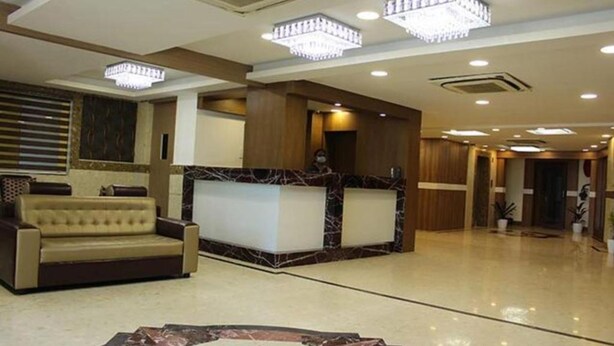 A lobby with a reception desk, a sofa, and a chandelier. - FabHotel Prime Stalin Pleasant Park (Chennai)