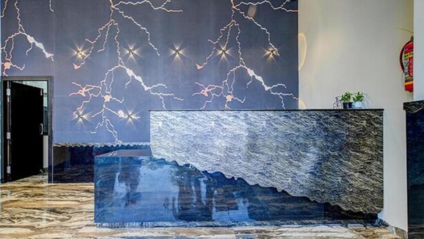 A reception area with a marble reception desk and a wall with a lightning pattern. - FabHotel Prime Kanha Shree (Indore)