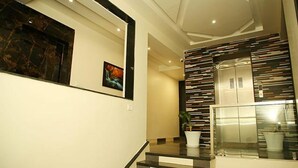 A modern interior with a staircase, a refrigerator, and a potted plant. - FabHotel Prime Kanha Shree (Indore)