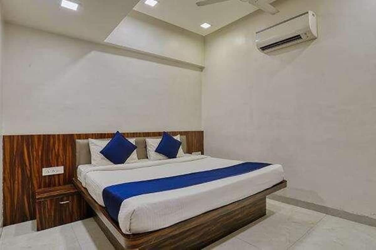A bedroom with a bed, wooden headboard, and a small bedside table.