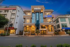 A hotel with a modern facade, a visible entrance, and a sign for the Rivlet Banquet. - Fabhotel Prime The Rivlet Mg Road (Gurugram)