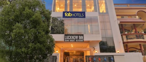 A building with a sign for 'FabHotels' and 'Lucknow Inn' indicating it is a hotel and banquet restaurant.