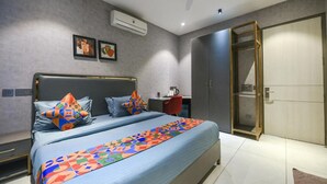 A modern bedroom with a bed, a desk, and a wardrobe. - FabHotel Prime Y Stay (Greater Noida)