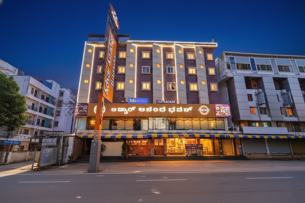 Un hotel de varios pisos con un letrero llamativo, múltiples ventanas y una fachada con restaurante.