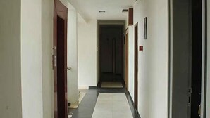 A hallway with doors on both sides, leading to rooms. - FabHotel Skylark Inn (Nashik)