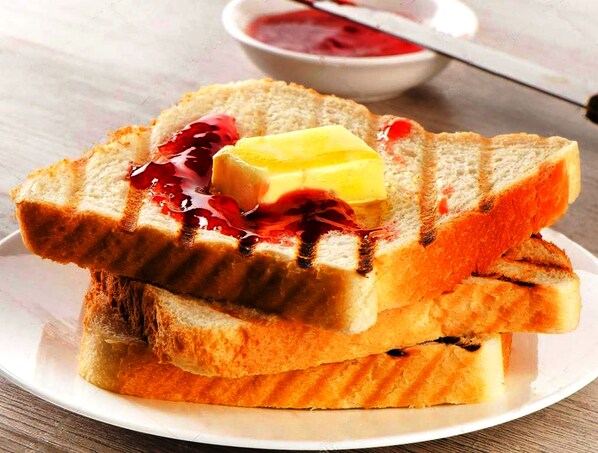 Enjoy a casual breakfast with toasted bread, butter, and jam.