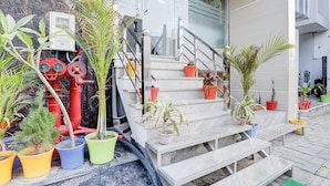 A staircase with potted plants, a fire hydrant, and a utility box. - FabHotel SMR (Agra)