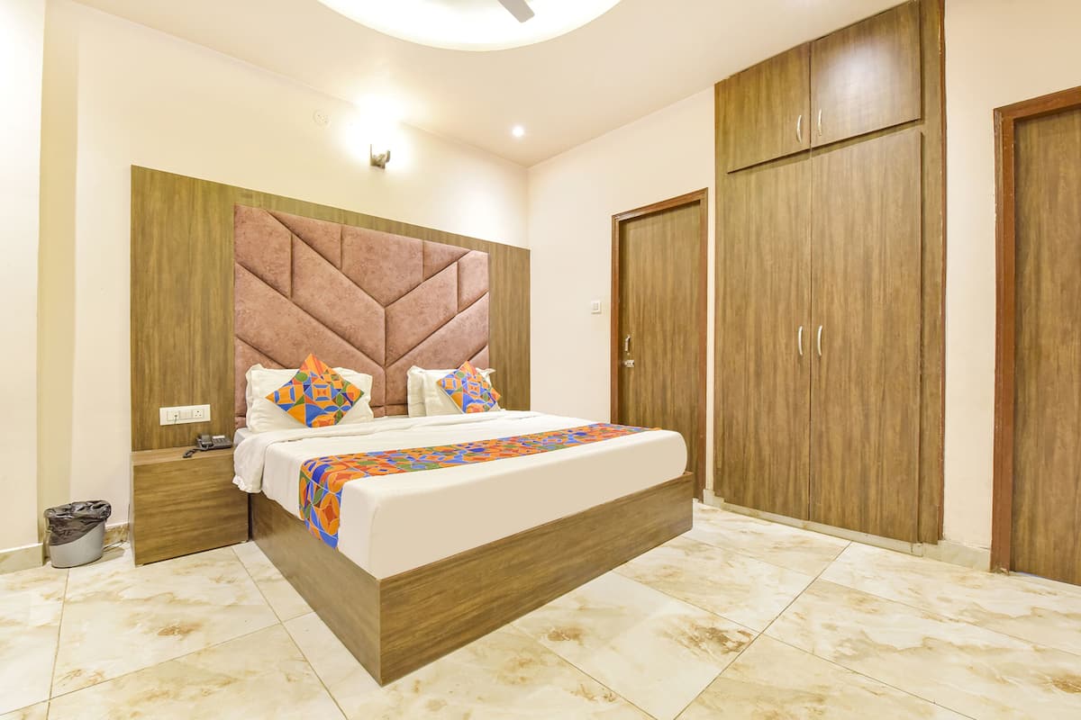 Un dormitorio con una cama grande, cabecera de madera y un armario.