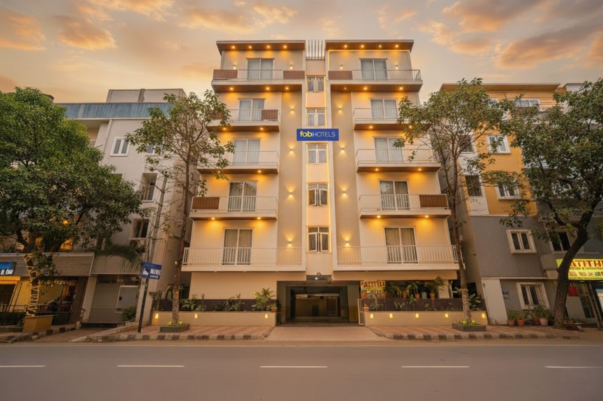 A multi-story hotel with a central entrance, balconies on each floor, and a sign indicating it is a hotel.