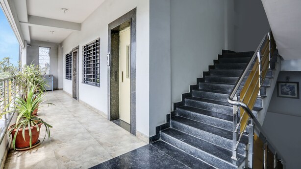 A modern interior with a marble staircase, potted plants, and a clean, minimalist design.