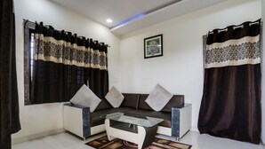 A living room with a sofa, coffee table, and curtains.