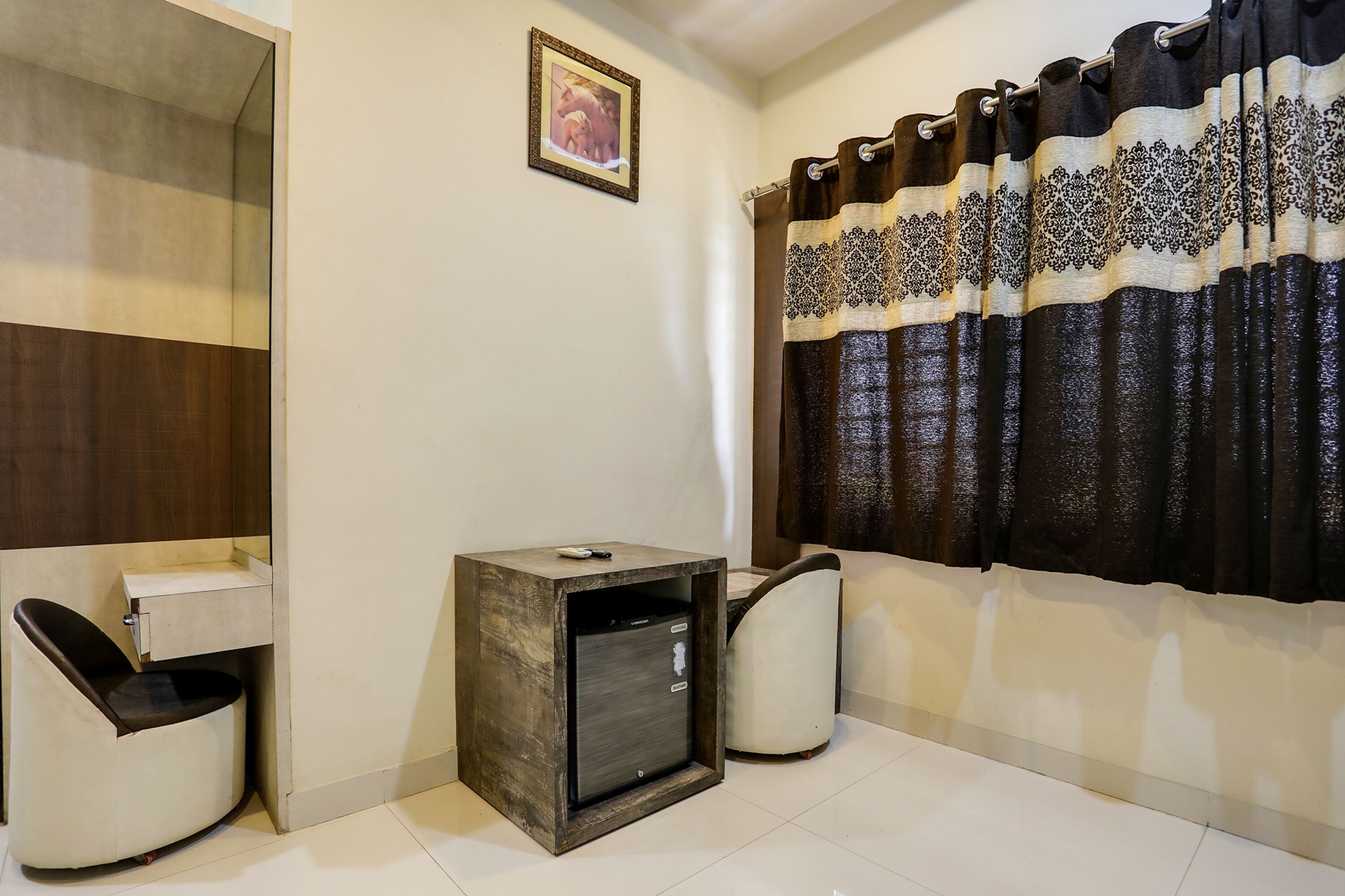 A modern bathroom with a wooden vanity, a small cabinet, and a mirror.