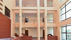 Un atrio de varios niveles con techos altos, ventanas amplias y un espacio central abierto con piscina.