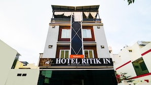 A hotel named "HOTEL RITIK IN" with a modern facade, a prominent vertical black and white design element, and a sign indicating it is part of the "fabexpress" chain. - FabHotel Ritik (Indore)