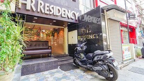 A storefront with a sign reading "HR RESIDENCY" and a motorcycle parked outside. - FabHotel HR Residency (Coimbatore)