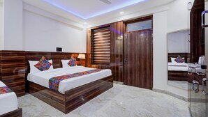 A modern hotel room with a large bed, a ceiling fan, wooden paneling, a bathroom with a mirror and sink, and a marble floor. - FabExpress Miss Too (Noida)