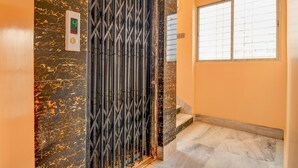 A staircase with a metal gate and a digital display. - FabHotel Dreamz Heaven (Barasat)