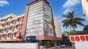 A hotel with a modern facade, a prominent 'FATHOTELS' sign, and a 'ROOM' sign indicating available accommodations. - FabHotel Leo Grand (Anekal)