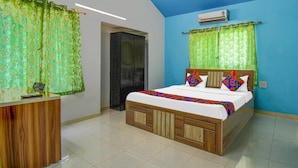 Un dormitorio con cama, escritorio y aire acondicionado.