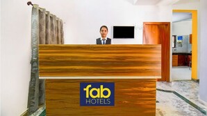 Mostrador de recepción de hotel con detalles de madera y un logotipo.
