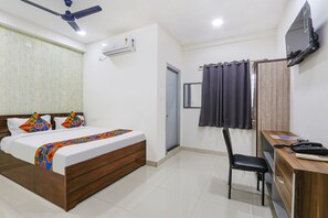 A bedroom with a bed, a desk, a chair, a TV, and an air conditioning unit. - Via Dream Connect - Narsingi (Hyderabad)