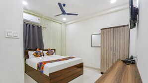 A bedroom with a bed, a wooden desk, a ceiling fan, an air conditioner, and a wardrobe. - Via Dream Connect - Narsingi (Hyderabad)