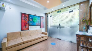A reception area with a sofa, a table with a vase, and a door marked "EXIT".