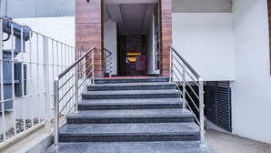 A set of black marble stairs leading to a building entrance with a metal handrail on both sides. - FabHotel Silver Key (Anekal)