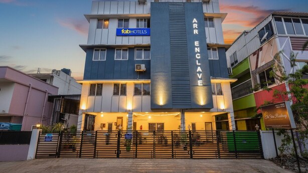 A multi-story building with a sign for 'fabHOTELS' and 'ARR ENCLAVE'.