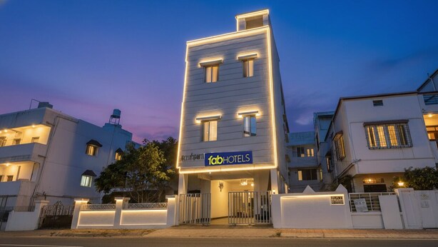 A modern building with a 'fabHOTELS' sign, featuring a gated entrance and a well-lit facade. - FabHotel Galaxy Airport Inn (Pune)