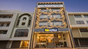 Une façade d’hôtel au design moderne, avec une enseigne bien visible indiquant « Hôtel Panchwati Regency » et « fabHOTELS ».