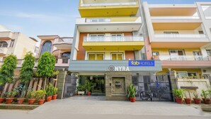 A multi-story hotel with a modern facade, balconies, and a sign for NYRA and Fabo Hotels. - FabHotel Nyra Residency (Gurugram)