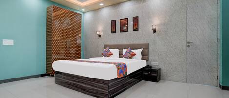 A modern bedroom with a large bed, a nightstand, a wall-mounted TV, and a ceiling fan.