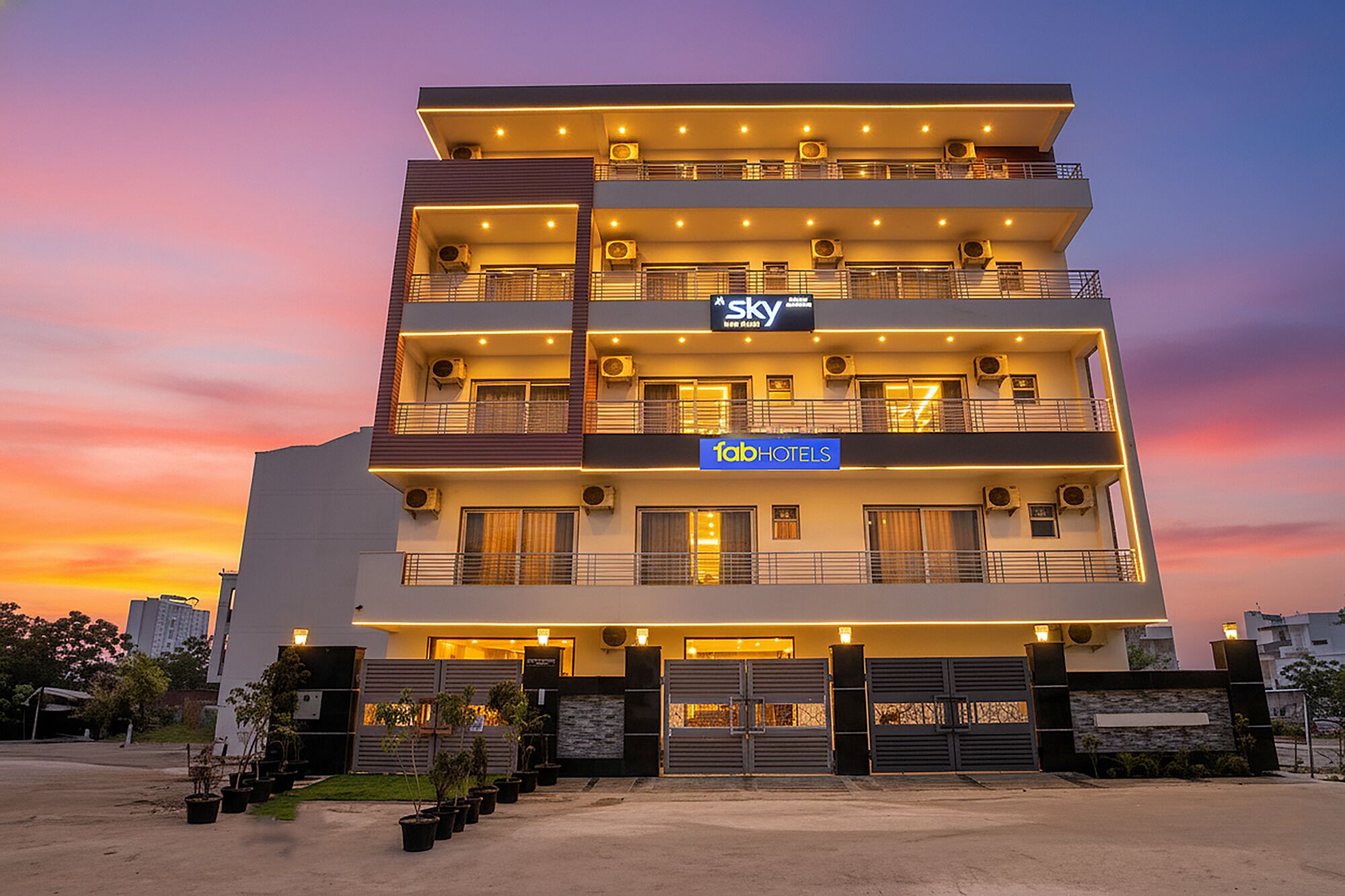 A multi-story hotel with balconies, air conditioning units, and a sign for 'Sky' and 'Fab Hotels'.