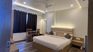 Un dormitorio moderno con una cama grande, un ventilador de techo y una mesita de noche.