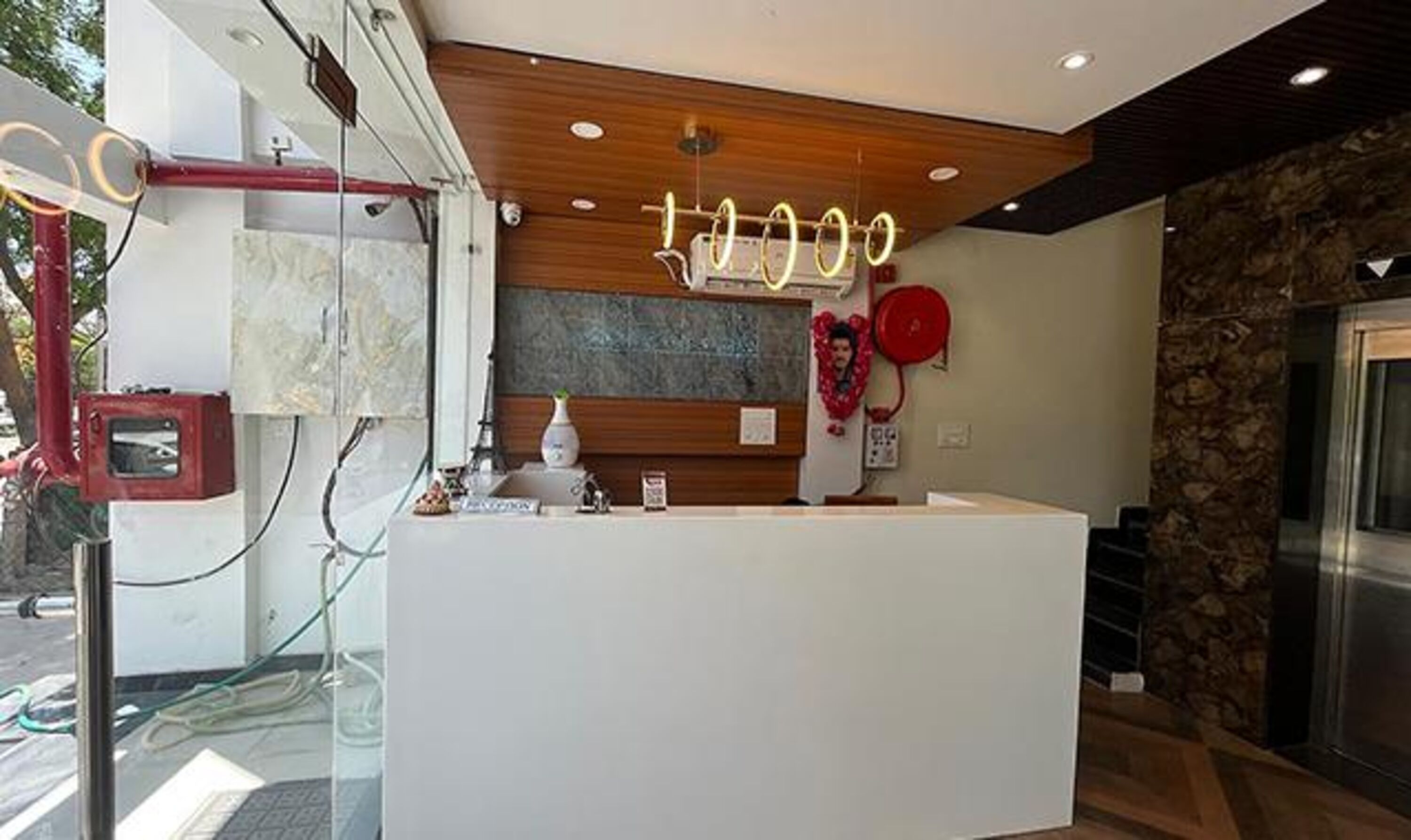 A reception area with a modern design, including a wooden panel wall, a reception desk, and a stone accent wall.