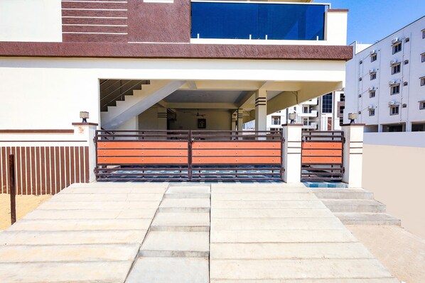 A modern building with a staircase leading to a covered entrance. - FabExpress New Balaji Home Stay (Srikalahasti)