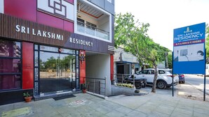 A multi-story building with a sign reading "Sri Lakshmi Residency" and a blue sign advertising A/C and non-A/C rooms. - FabExpress Sri Lakshmi Residency (Dehradun)