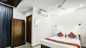 A bedroom with a bed, a wardrobe, a ceiling fan, and an air conditioning unit. - FabHotel VK’s Bahadurpally- Nr. Mahindra University, Bahadurpally, Jeedimetla (Hyderabad)