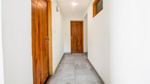 A hallway with wooden doors and tiled flooring. - FabHotel Mountain View Cottage (Manali)