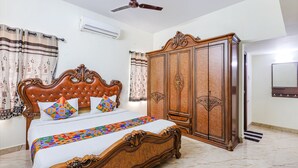 A bedroom with a wooden bed, a wardrobe, and a ceiling fan. - FabExpress Fen Breeze (Chennai)